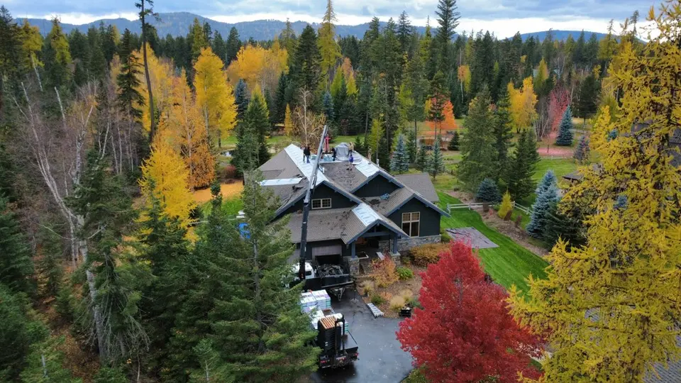 Aerial drone photo of connected shingle rooflines on a multi-building Flathead property