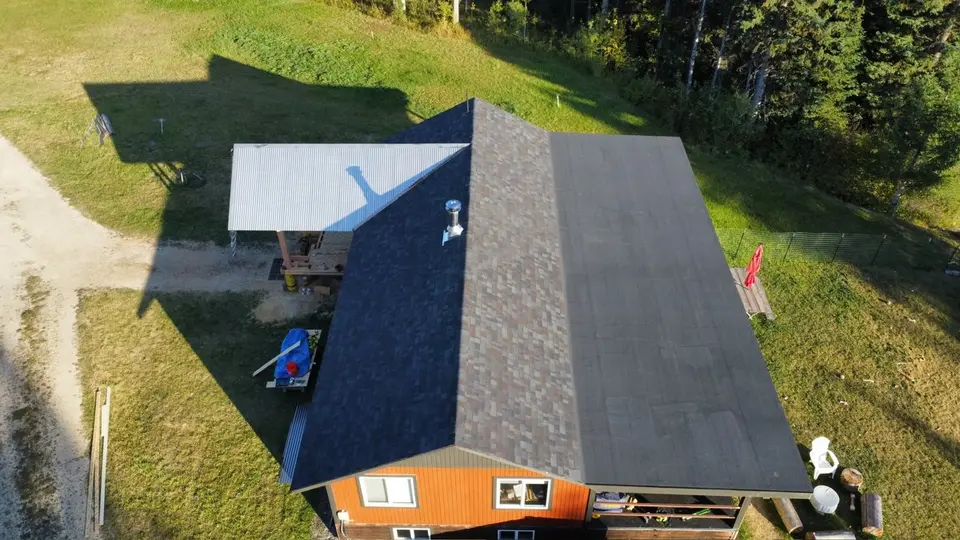 Drone photo looking down a shingle roof ridge line during an inspection