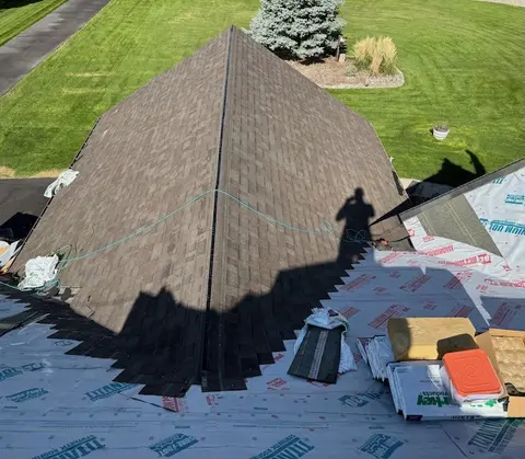 Roofer installing new architectural asphalt shingles